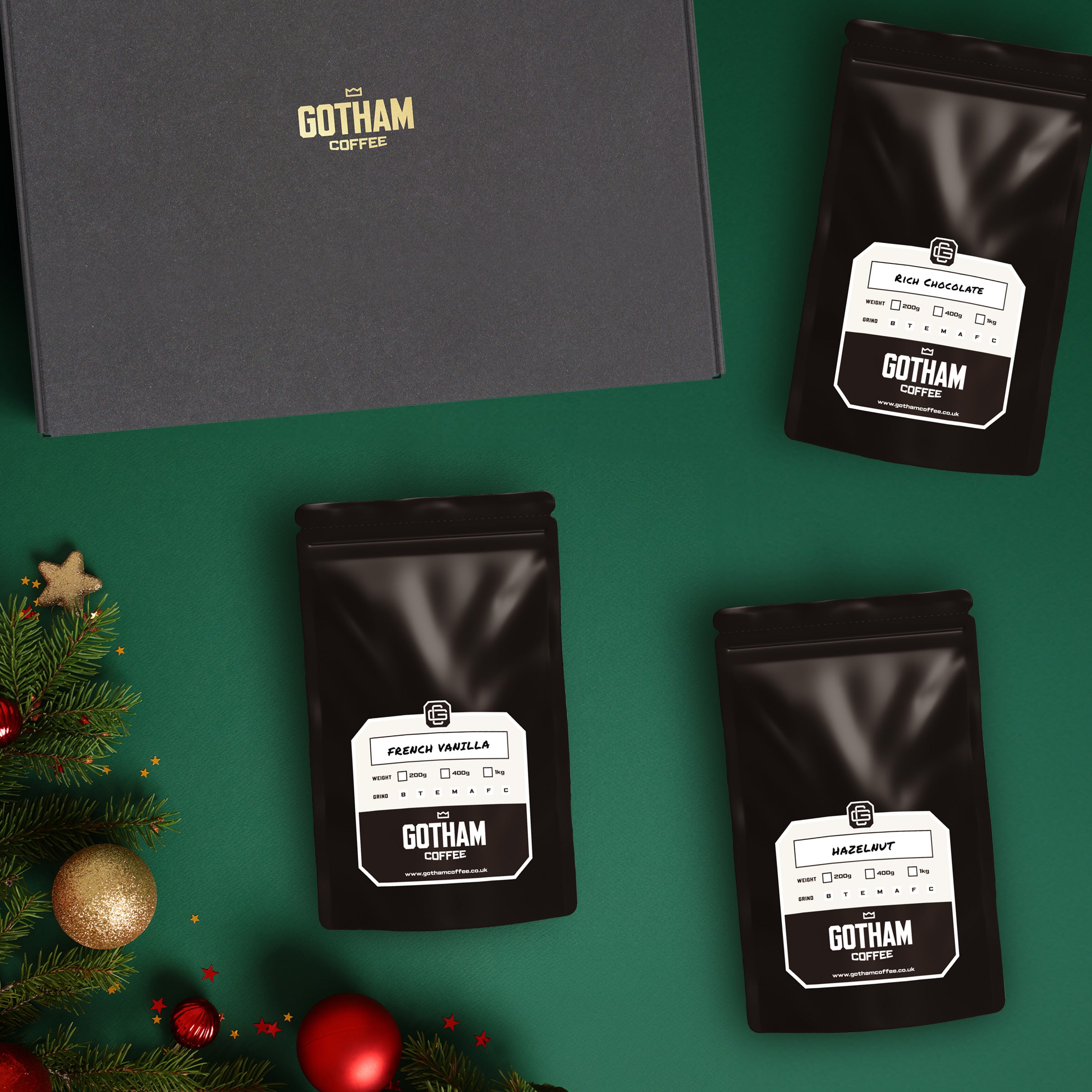Gotham Coffee packages on a green background with Christmas decorations.