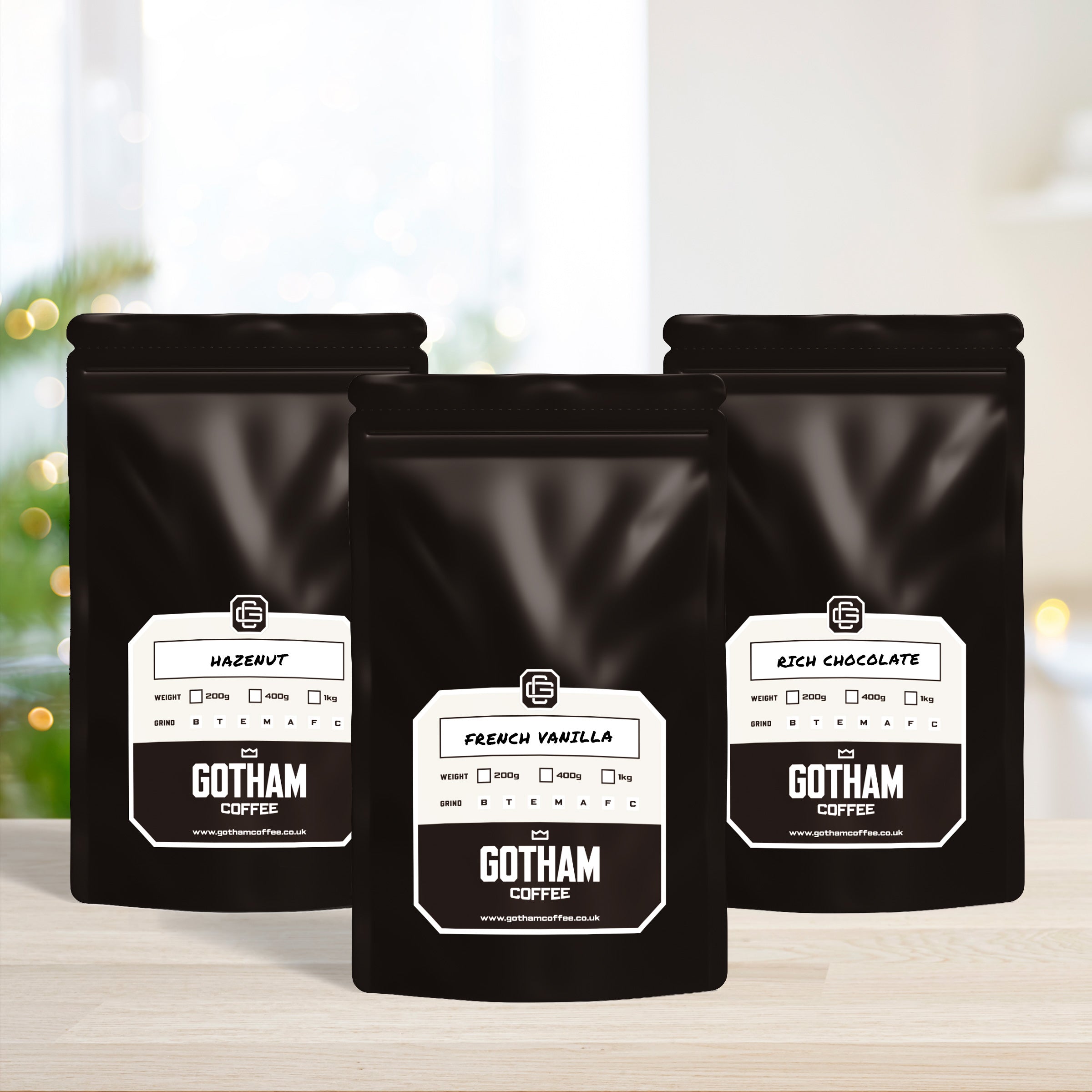 Three black Gotham Coffee bags with labels on a blurred background